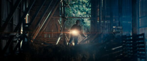 Young woman pointing a torch into a barn