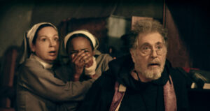 Two distressed nuns stood behind a priest