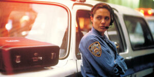 Woman stood resting against a police car
