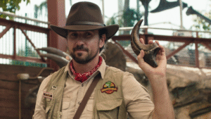 Man wearing a hat and holding a dinosaur claw