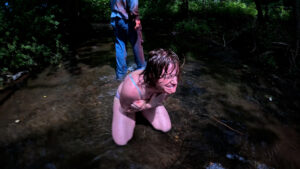 Distressed woman kneeling in a river