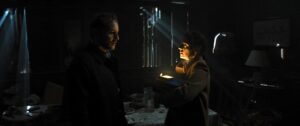 A man and a woman facing each other in reduced light